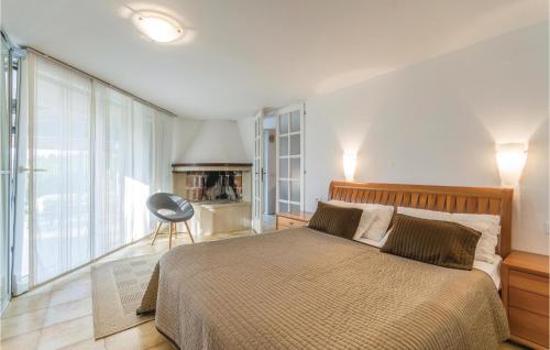a bedroom with a bed and a chair in it at Gorgeous Apartment In Pula With Outdoor Swimming Pool in Pula