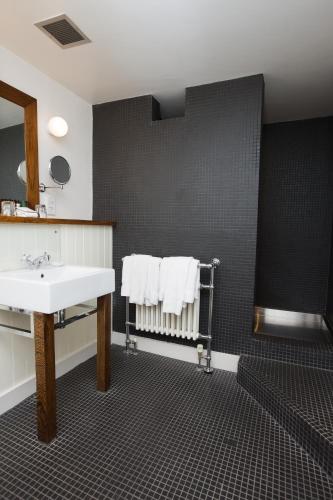 a bathroom with a sink and a mirror and towels at Hotel du Vin & Bistro Harrogate in Harrogate