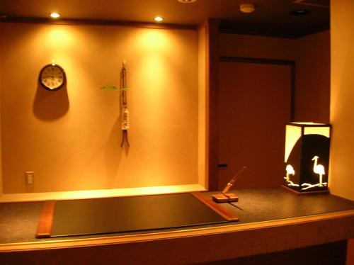 a room with a clock and a tank on the wall at Saginoyusou in Yasugi