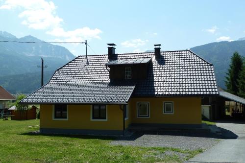 a yellow house with a black roof at Ferienhaus Strasswirt in Jenig
