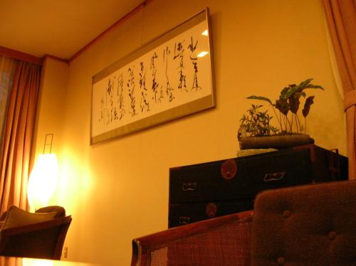 a living room with a picture on the wall and a lamp at Saginoyusou in Yasugi