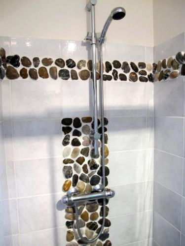 La salle de bains est pourvue d'une douche avec des pierres au mur. dans l'établissement La Cazalère, à Campan