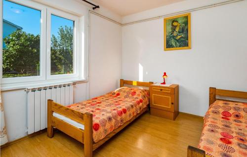 a bedroom with two beds and a dresser and a window at Stunning Apartment In Kapelica With House A Panoramic View in Raša