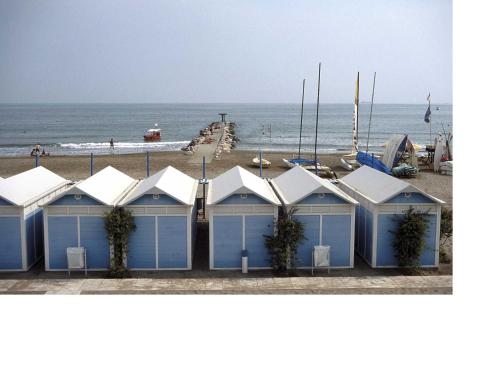 a row of blue beach huts on a beach at Hotel Villa Tiziana in Venice-Lido