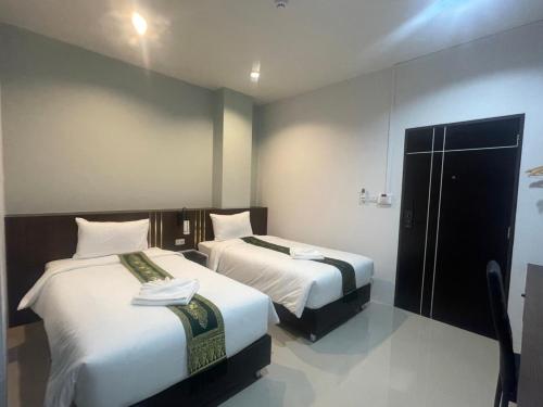 a hotel room with two beds with white sheets at The Bliss Boutique Hotel 