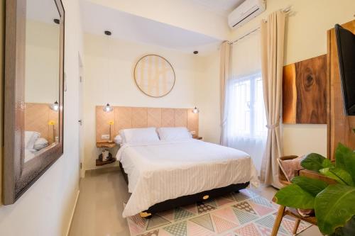 a bedroom with a large bed and a mirror at Siji Gempol Vacation Home in Yogyakarta