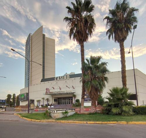 un edificio con palmeras delante en Departamentos Kairos H en Mendoza