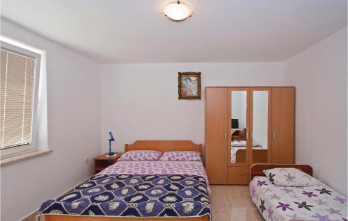 a bedroom with a bed and a cabinet in it at Cozy Apartment In Liznjan With Wifi in Ližnjan