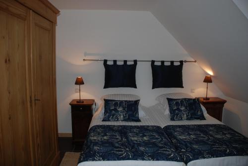 sypialnia z łóżkiem z czarno-białą pościelą i poduszkami w obiekcie Les Bleuets w mieście Scharrachbergheim Irmstett