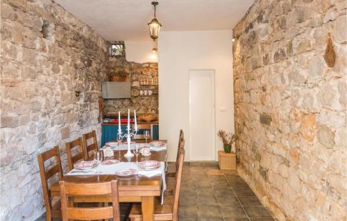 a dining room with a table and a stone wall at Cozy Home In Podgora With Wifi in Igrane