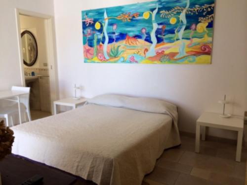 a bedroom with a bed and a painting on the wall at Dimora Sul Porto in Savelletri di Fasano