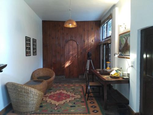 a hallway with a desk and a table and chairs at Samira's Birds & Butterflies Park-Spashram Ganga Beach Retreat in Rishīkesh
