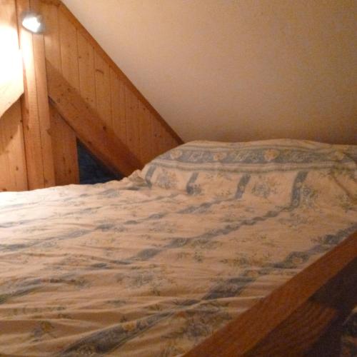 uma cama num quarto com uma cabeceira em madeira em Gîte &quot;La Bergerie&quot;- Chalet indépendant em Kirchberg
