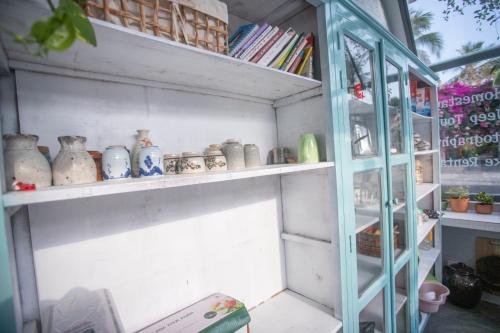 Ấp Thiện Phước的住宿－Ẩn Homestay Mũi Né，一间装满花瓶的书架和窗户的房间