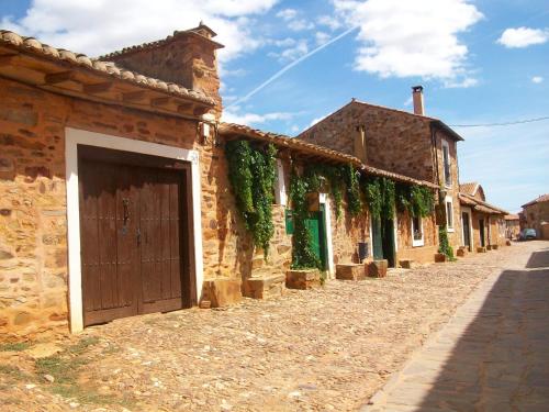 a brick building with a door on the side of a street at Apartamentos turísticos LAS CARBALLEDAS in Rabanal del Camino