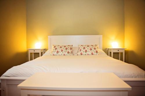 a white bed with two pillows on top of it at Apartamentos turísticos LAS CARBALLEDAS in Rabanal del Camino