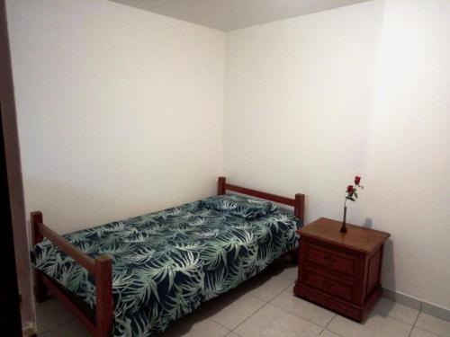 1 dormitorio con cama y mesita de noche de madera en Sucesac en Lima