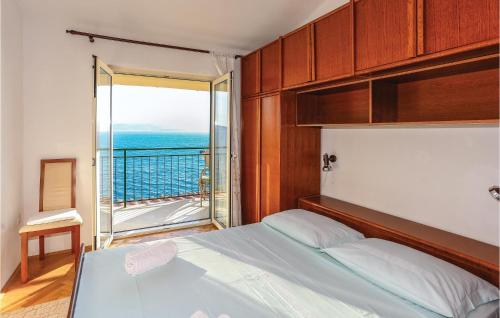 a bedroom with a bed with a view of the ocean at Nice Apartment In Omis With 3 Bedrooms And Wifi in Pisak