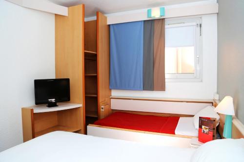 a small bedroom with a bed and a window at ibis Orange Centre in Orange