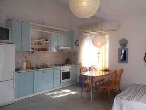 a kitchen with blue cabinets and a table with chairs at Apartments Vanda in Vrboska