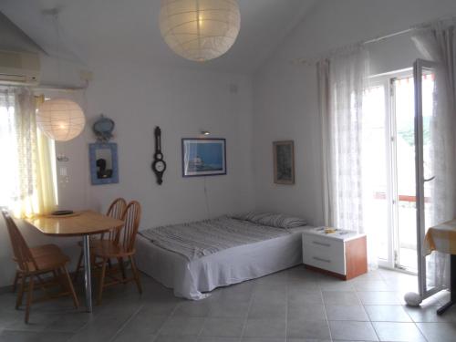 a bedroom with a bed and a table and chairs at Apartments Vanda in Vrboska
