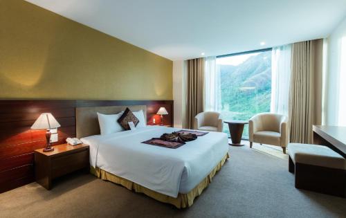 a hotel room with a bed and a large window at Muong Thanh Grand Nha Trang Hotel in Nha Trang