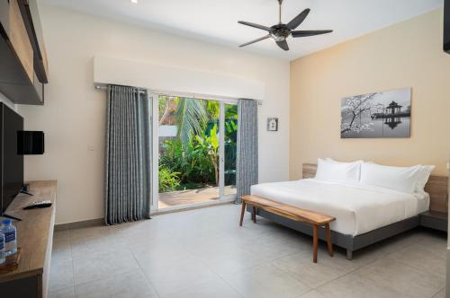 um quarto com uma cama e uma grande janela em The Friendship Villa by Amatak em Siem Reap