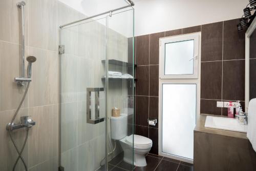a bathroom with a toilet and a glass shower at The Friendship Villa by Amatak in Siem Reap