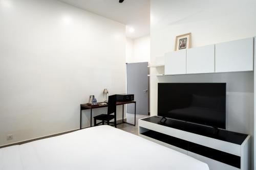 a white bedroom with a bed and a desk at The Friendship Villa by Amatak in Siem Reap