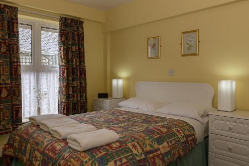 ein Schlafzimmer mit einem großen Bett mit Handtüchern darauf in der Unterkunft Killarney Self-Catering - Haven Suites in Killarney