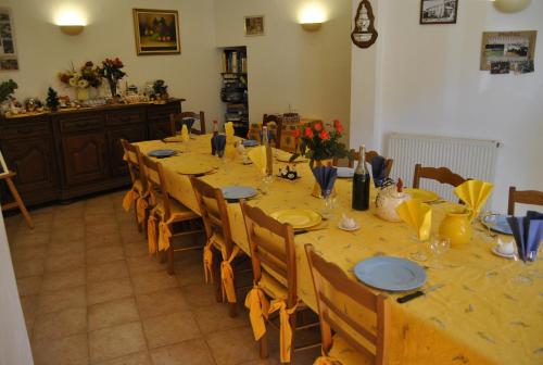 - une salle à manger avec une grande table agrémentée de fleurs et d'assiettes bleues dans l'établissement Ferme de Sejour Rebuffel, à La Roque-Esclapon