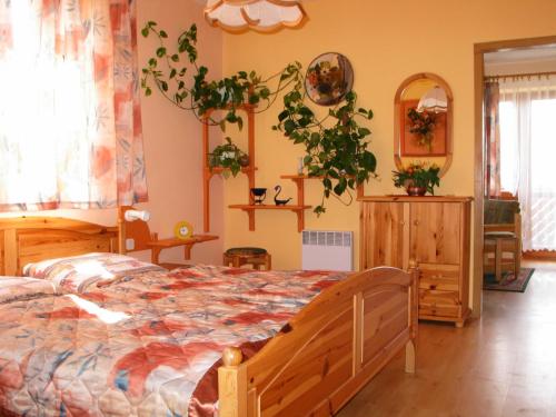 1 dormitorio con 1 cama y plantas en la pared en Pensjonat Lotos en Krynica Morska