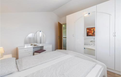 ein weißes Schlafzimmer mit einem Bett und einem Badezimmer in der Unterkunft 3 Bedroom Nice Home In Labin in Raša