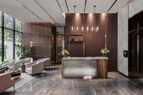 a lobby with a reception desk and chairs at Wyndham Bangkok Queen Convention Centre in Bangkok