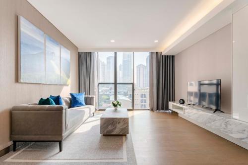 a living room with a couch and a tv at Wyndham Bangkok Queen Convention Centre in Bangkok