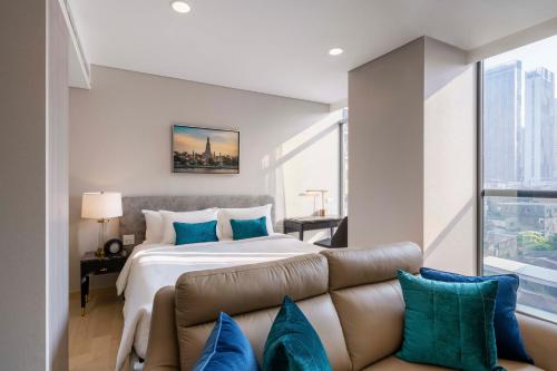 a bedroom with a large bed and a couch at Wyndham Bangkok Queen Convention Centre in Bangkok