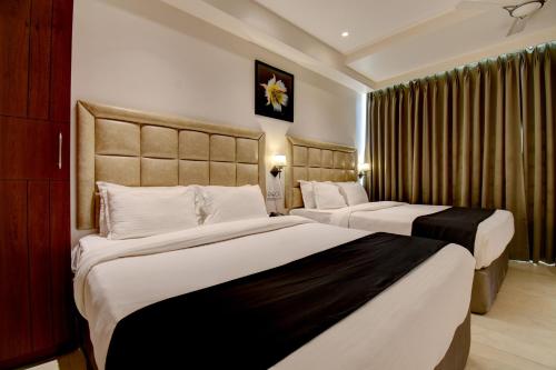 a hotel room with two beds in a room at Elite Homes in Aurangabad