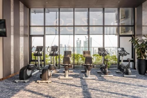 a row of exercise equipment in a building with windows at Wyndham Bangkok Queen Convention Centre in Bangkok