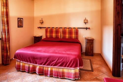 a bedroom with a red bed in a room at Agriturismo Residenza il Girasole in Bettona
