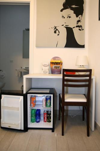 a chair sitting next to a small refrigerator at Orchidea Rooms & Suites in Civitanova Marche