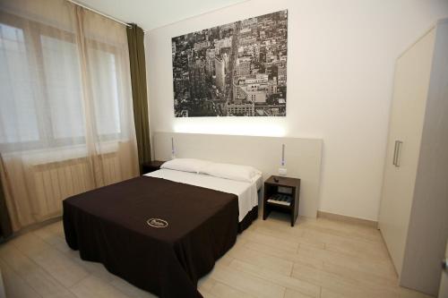 a bedroom with a bed with a black table at Orchidea Rooms & Suites in Civitanova Marche