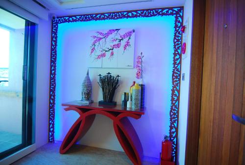 a room with a red table in front of a wall at A&L Inn 戀灣旅棧 in Nanwan