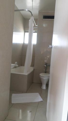 a bathroom with a tub and a toilet and a sink at Coastlands Durban Self Catering Holiday Apartments in Durban