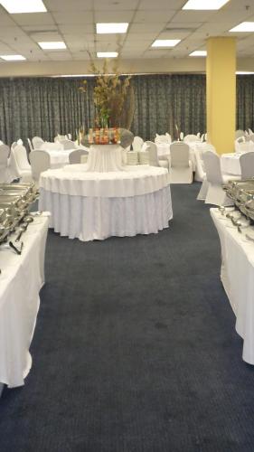 a large room with white tables and white chairs at Coastlands Durban Self Catering Holiday Apartments in Durban