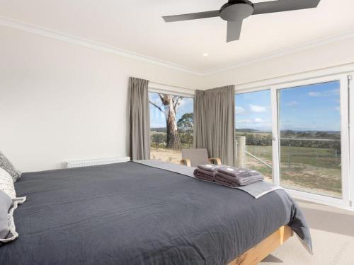 a bedroom with a bed and a large window at On a Hill in Marlow