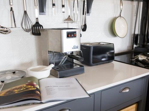 a kitchen with a book on a counter with a microwave at On a Hill in Marlow