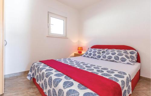 1 dormitorio con 1 cama con edredón rojo y blanco en Stunning Apartment In Podaca With Kitchen, en Podaca