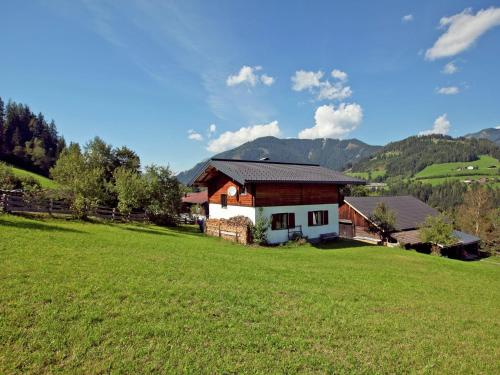 a house in a field with a green field at Lush Holiday Home in H ttau near Ski Area in Hüttau
