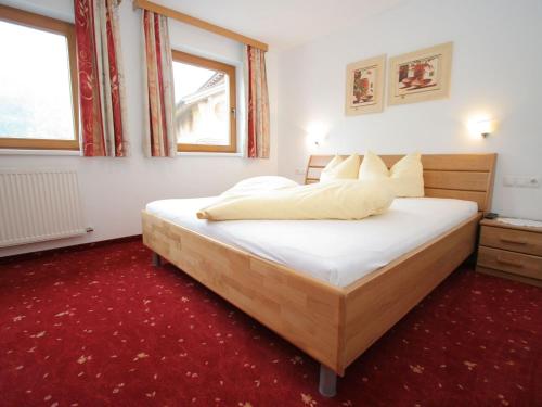 ウダーンスにあるSpacious Apartment in Uderns near Ski Areaのベッドルーム1室(赤いカーペット敷きの大型ベッド1台付)