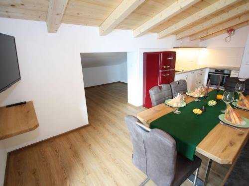 a dining room with a green table and chairs at Exquisite vacation apartment in Mittersill near ski area in Mittersill